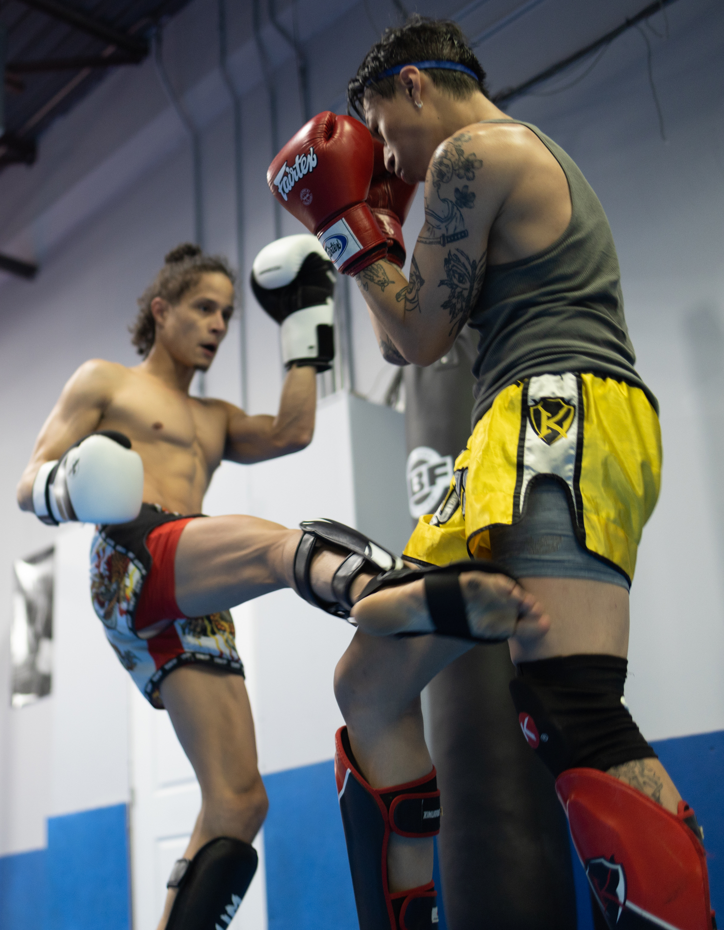 Image of two men sparring during a Muay Thai lesson at Ultimate Martial Arts & Fitness in Mississauga, Ontario, Canada. One man is kicking the other